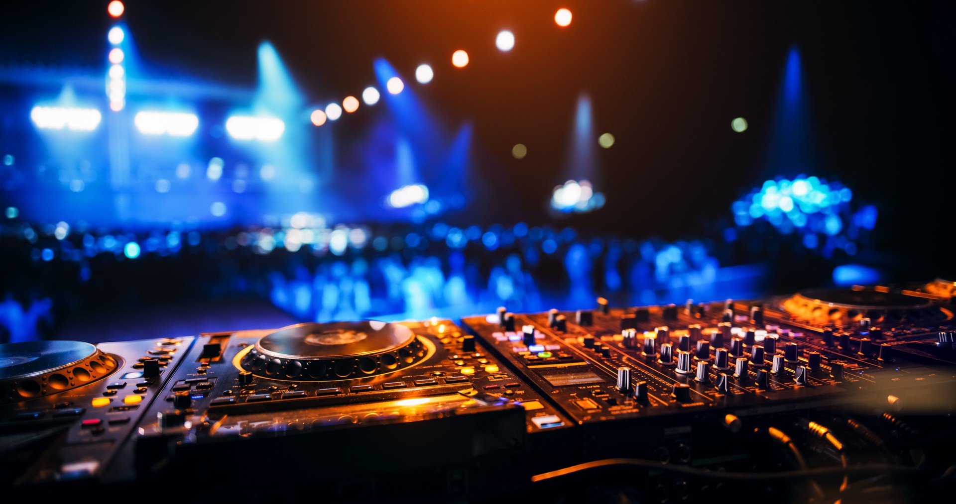 Establishing Footage with Professional DJ Equipment on a Club Stage. Mixing Decks, Controllers and Other Gear Standing on a Table, Ready to Be Used by a Popular Music Artist in Front of Audience Establishing Footage with Professional DJ Equipment on a Club Stage. Mixing Decks, Controllers and Other Gear Standing on a Table, Ready to Be Used by a Popular Music Artist in Front of Audience